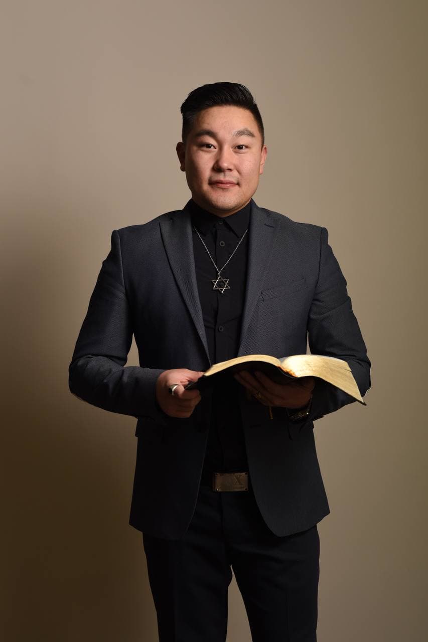 John Bayarsaikhan holding an open Bible